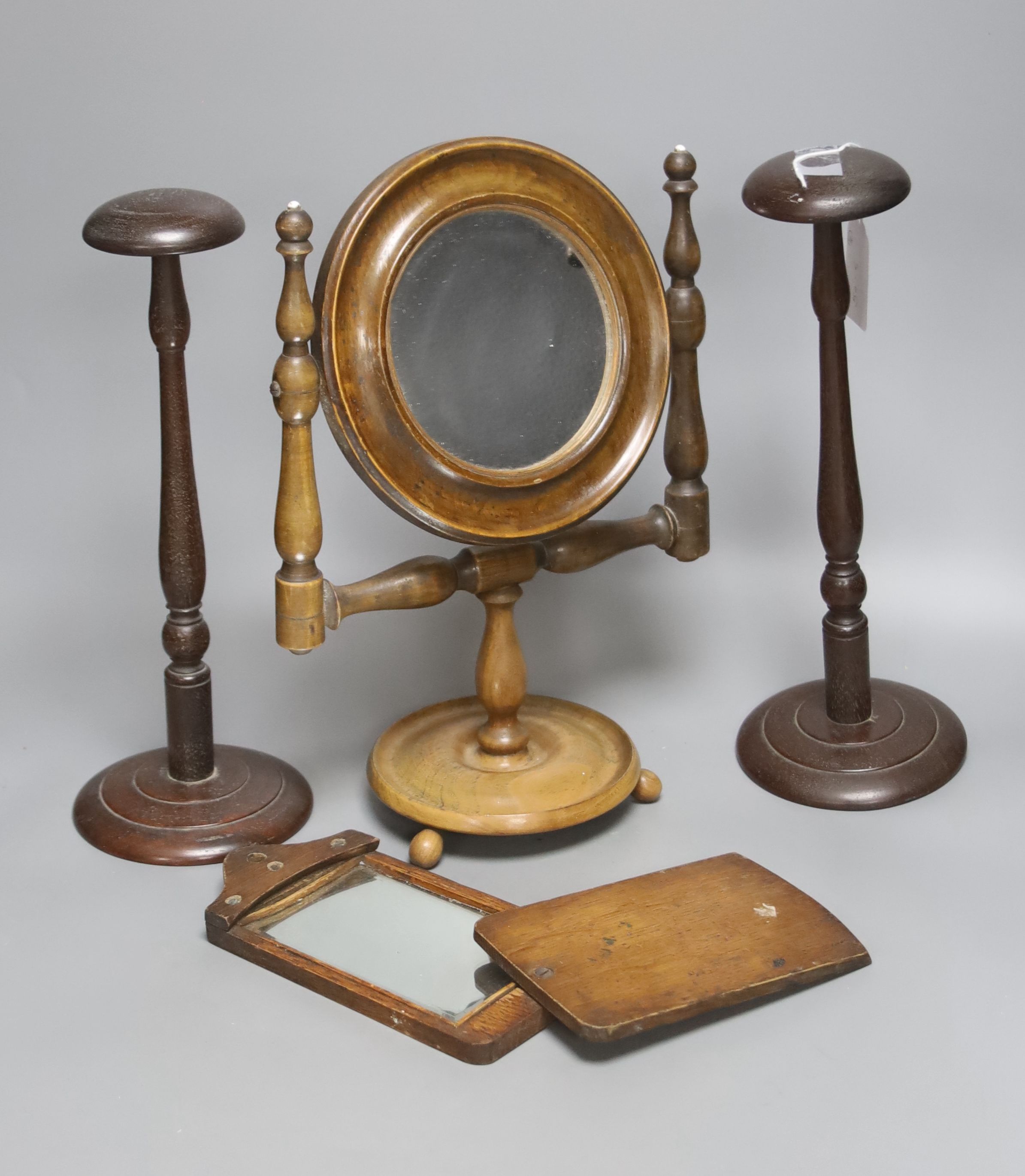 A 19th century walnut shaving mirror, height 31cm, two mahogany wig stands and a travelling mirror